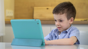 学龄前儿童坐在一张桌子上看平板电脑16秒视频