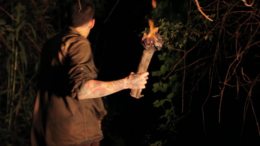 晚上男孩在树林里手拿着火炬3视频