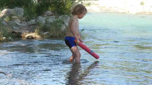 金发男孩在河里玩耍慢动作视频