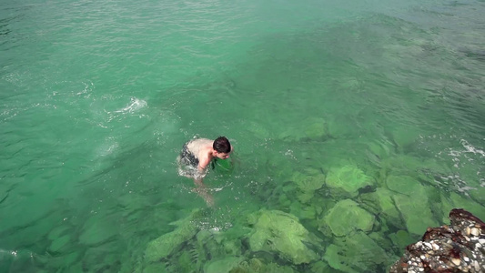 快乐的男孩在海绿松石水中游泳慢动作慢动作视频