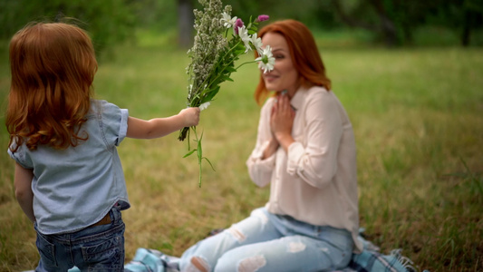 美丽的孩子送鲜花给微笑的母亲视频