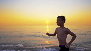 男孩跑来跑去在海边慢跑以躲避日落8秒视频