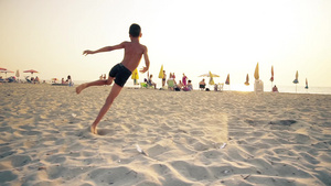 男孩在海滩沙上微笑地奔跑跳跃22秒视频