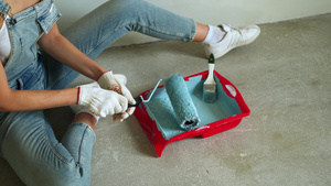 女工用桶装滚滚筒在公寓里油漆墙壁或12秒视频