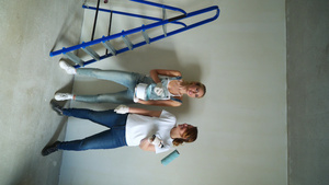 两名女工用滚滚机在墙壁上涂漆以14秒视频