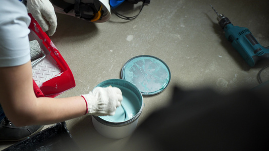 女工在罐子中混合油漆以漆公寓或房屋的墙壁视频