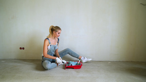 女工用桶装滚滚筒在公寓里油漆墙壁或11秒视频