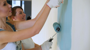 两名女工在公寓或房屋中用滚滚机油漆墙壁13秒视频