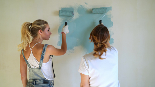 两名女工在公寓或房屋中用滚滚机油漆墙壁视频