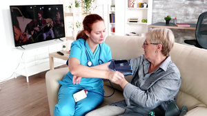 测量老年妇女血压的女护士16秒视频