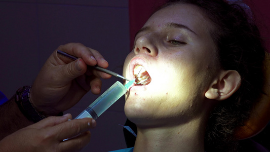 带注射器针头的牙医在口腔手术前对牙道进行消毒视频