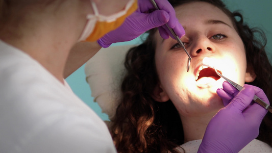 牙医在牙医检查病人的牙齿视频