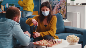 带着面罩的焦点女性与男性朋友玩象棋18秒视频