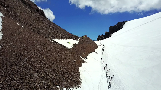 一大群登山者爬上顶端视频