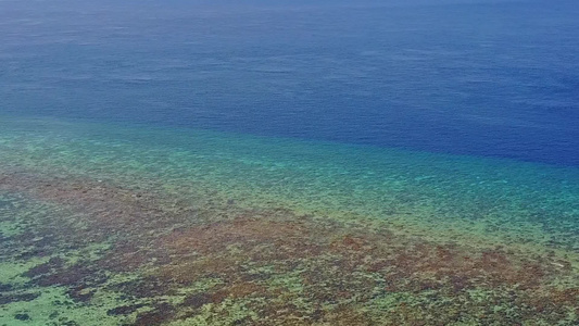 利用蓝色海洋和靠近波浪的白色沙滩背景进行热带湾海滩视频