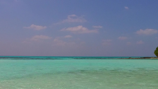 蓝色绿色环礁湖和接近冲浪的白色沙滩背景的美丽旅游海滩视频