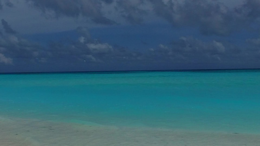 阳光明媚的旅游业通过海浪附近有白色沙滩背景的绿绿海视频