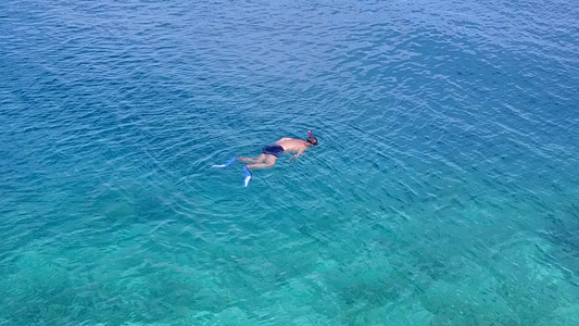 日落前水蓝色水和白色沙滩背景的田园诗般的海岸线海滩视频