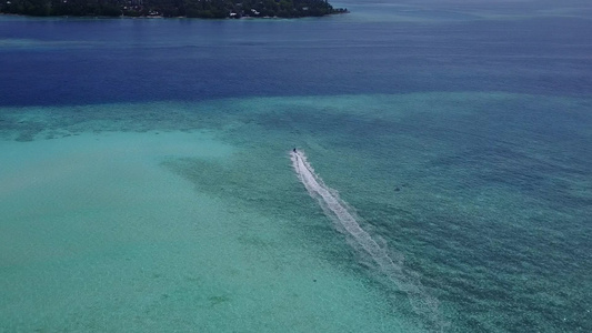 以棕榈附近的蓝色环礁湖和白色沙滩背景进行完美的旅游视频