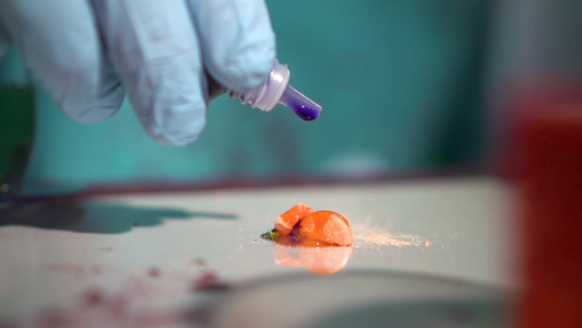 在非法实验室用橙色药丸的管式漏水器将消失的毒药洒在视频