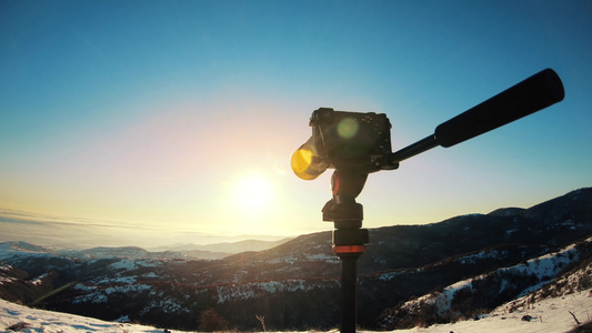 摄影师使用摄像头和三脚架拍摄在黄昏的美丽景色图画冬季视频