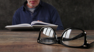 男人在读书拿眼镜脱焦概念21秒视频