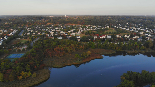 沿河的城镇地区与秋天风景中的私人房屋长凳相对的空中视频