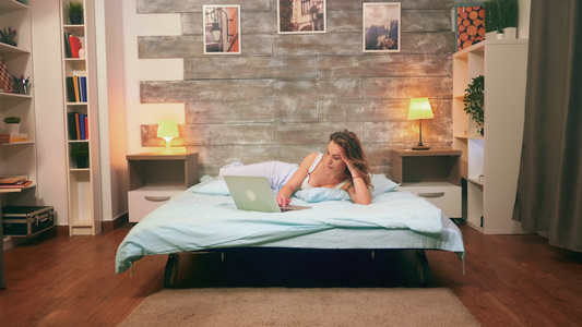 穿着睡衣用笔记本电脑穿睡衣的年轻美女视频