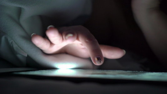 年轻女性睡前在床上使用平板药即手机上瘾者的概念视频