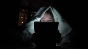 年轻女性睡前在床上使用平板上瘾者的概念11秒视频