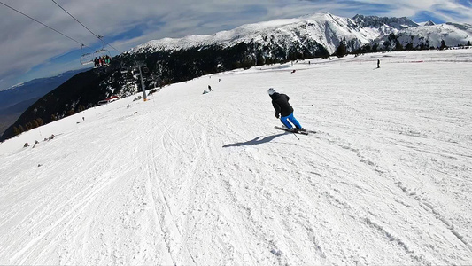 专业滑雪者在山峰晴朗的日子里从斜坡滑下电影超级慢动作视频