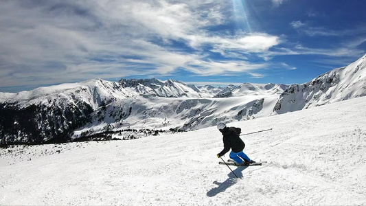 在阳光明媚的冬日在山中慢动作观看高山滑雪者在滑雪坡视频