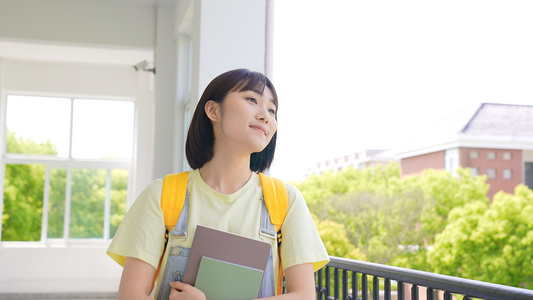 青春洋溢的女大学生走在校园走廊上视频