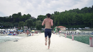 年轻男子跑步光脚在海滩码头慢跑电影风景慢动作27秒视频