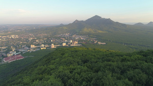 早上在城市上空的山坡上飞过绿色森林背景是绿色的山地15秒视频