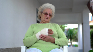 手臂受伤的年长老年妇女坐着说话13秒视频