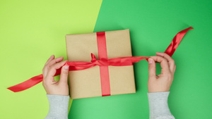 绿背景的礼物盒上脱红丝绸带10秒视频