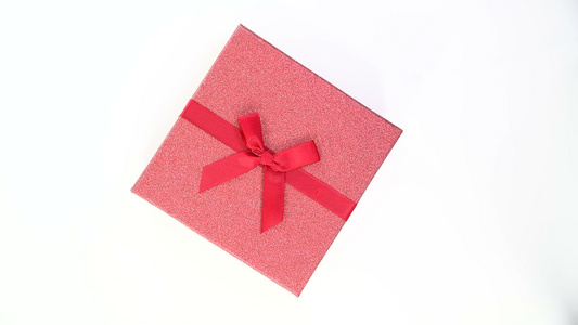 红色礼品盒的顶部视图白色背景上隔着丝带视频
