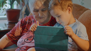 外祖母和孙孙子在家使用平板药片15秒视频