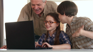 老人和孙子孙女在笔记本电脑上娱乐10秒视频
