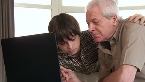 小男孩用笔记本电脑帮他爷爷17秒视频