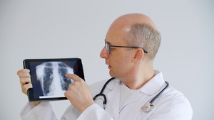 秃头医生在远程咨询时在平板电脑屏幕上显示肺部x射线22秒视频