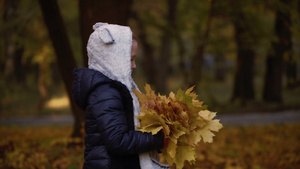 七岁的女孩在秋天走进公园手里握着叶子16秒视频