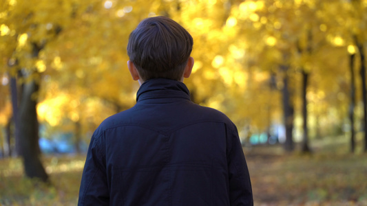 秋天公园穿黑大衣的年轻人录像拍下来了视频