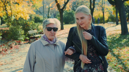 秋天在公园和金发女孩一起散步的老人视频