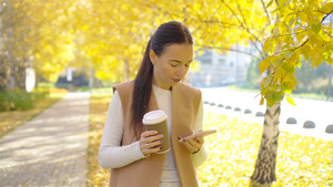 秋天概念美丽的女人在秋季公园喝咖啡在秋天的树叶下11秒视频