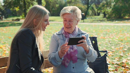 大奶奶在智能手机上展示孙女照片请看她的孙女照片视频