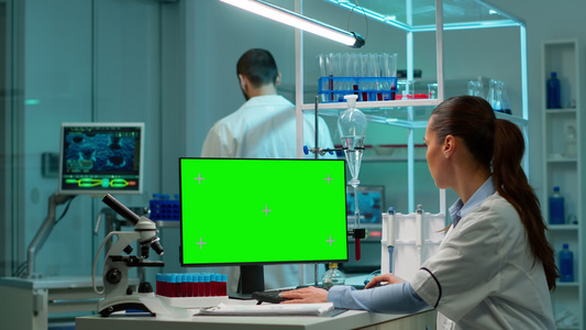 科学家坐在桌上用模拟屏幕处理个人计算机工作a使用模拟视频