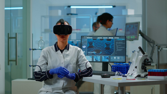 专业科学家佩戴虚拟现实眼镜在实验室里使用医学推介方式视频