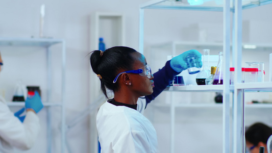 非洲女化学家研究员在实验室使用玻璃设备视频